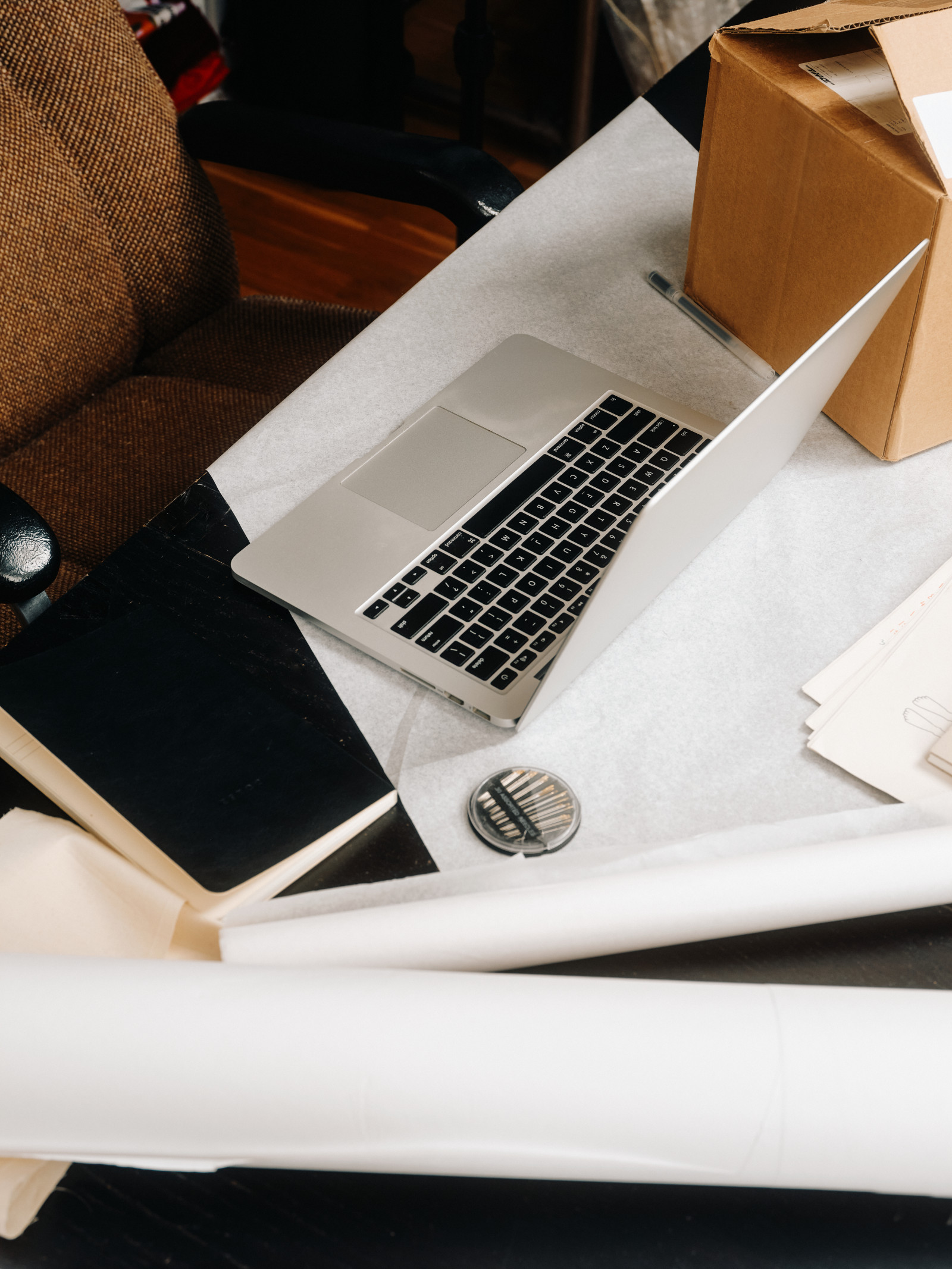 A laptop and notebooks on a workspace